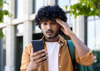 étudiant devant son smartphone déçu